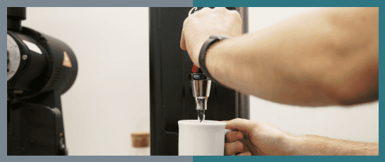 A barisita dispensing boiling water from the Parisi E-Bev Countertop Boiling Water Dispenser