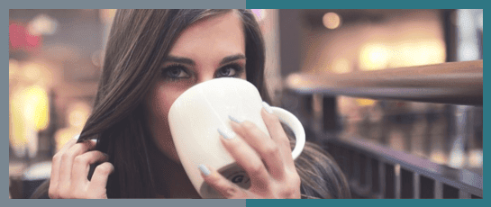 A customer at a coffee shop enjoying a coffee made with the Parisi E-Bev Boiling Water Dispenser