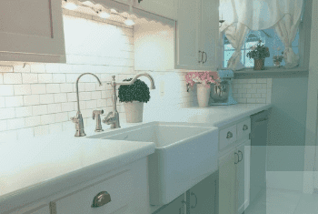 A 4 Stage water filter and faucet installed in a farmhouse sink