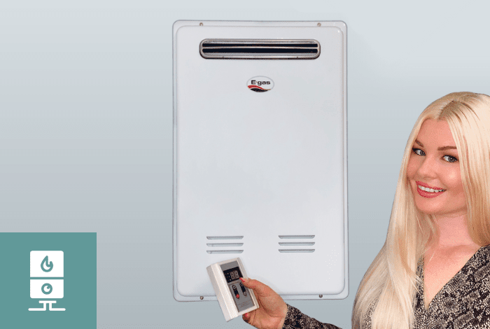 A woman adjusting her gas geyser temperature with her remote control