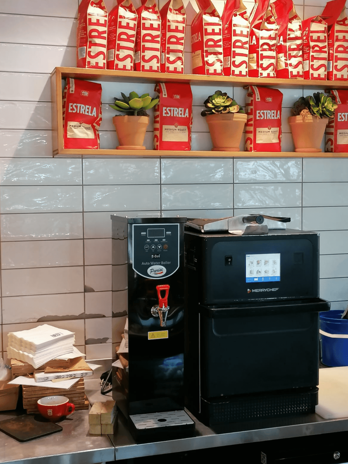A Parisi E-Bev boiling water dispenser alongside a sandwich toaster at a coffee shop