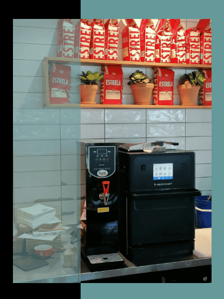 The Parisi E-Bev Boiling Water Dispenser alongside a sandwich toaster at a coffee shop, ideal for complementing other appliances