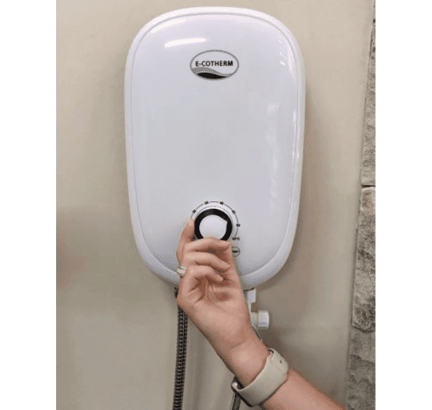 A woman adjusting the temperature of the e-cotherm instant water heater.