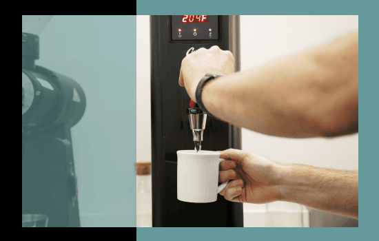 A barista dispensing boiling water from the Parisi E-Bev