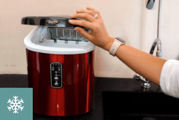 A woman lifting up the lid of the Parisi Ice Maker