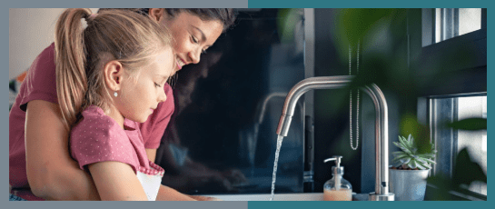 A chef washing dishes with instant hot water