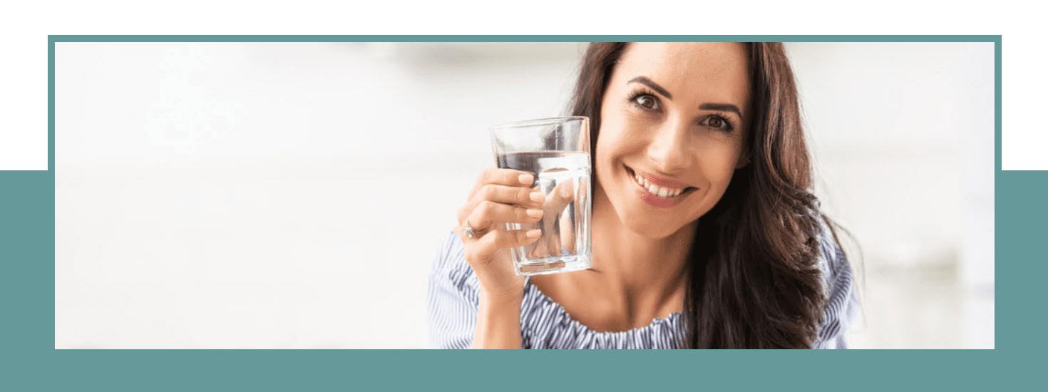 A woman with a glass of purified water from the E-Pure water filter