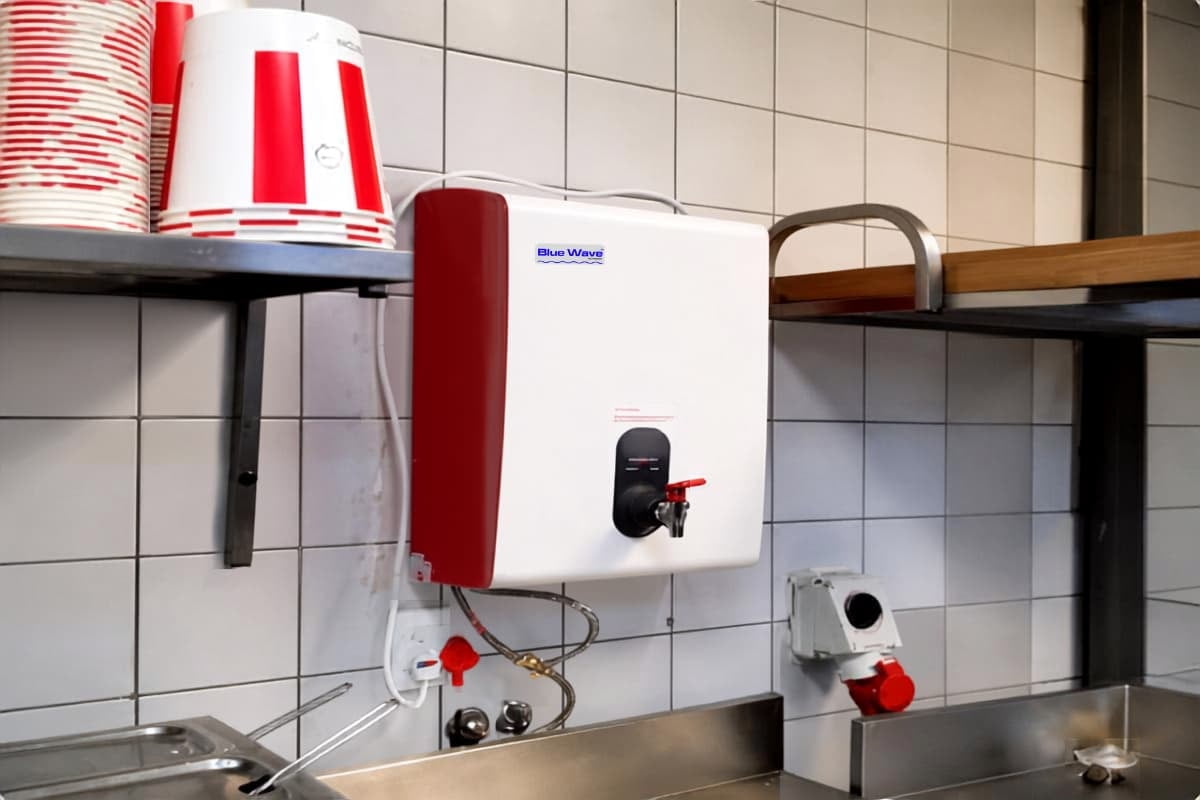 Custom red BlueWave boiling water dispenser installed at a KFC restaurant.