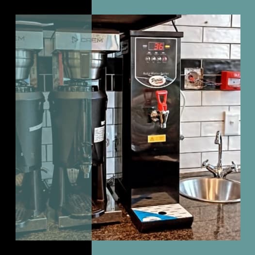 Parisi E-Bev countertop boiling water dispenser on the service counter beside espresso grinders at Mugg & Bean, Phesantekraal, Durbanville