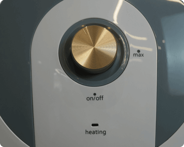 Close-up of the Parisi Mini Geyser temperature dial with on/off and heating indicators